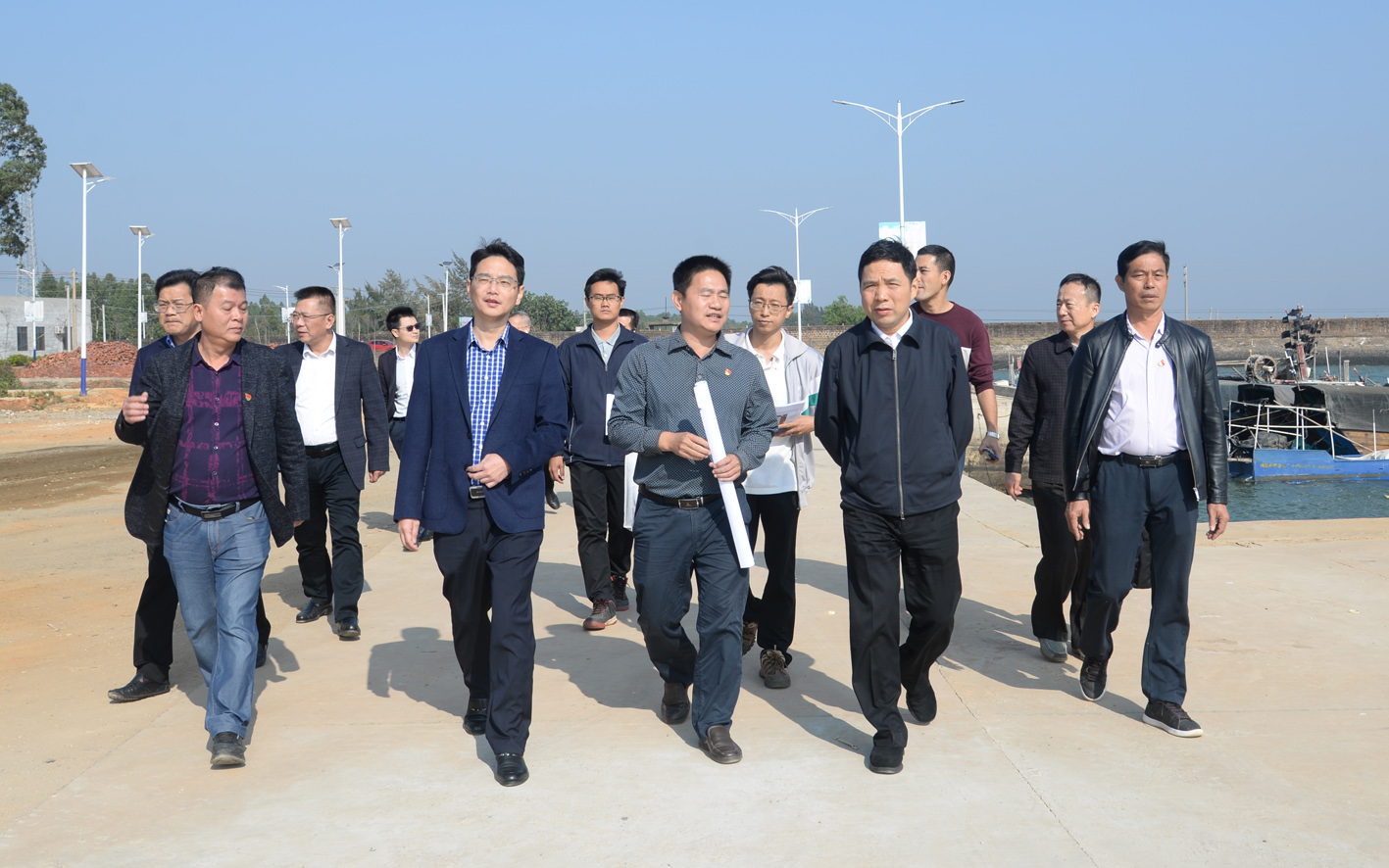 沿着平坦整洁的硬底化村道边走边察看村容村貌.JPG