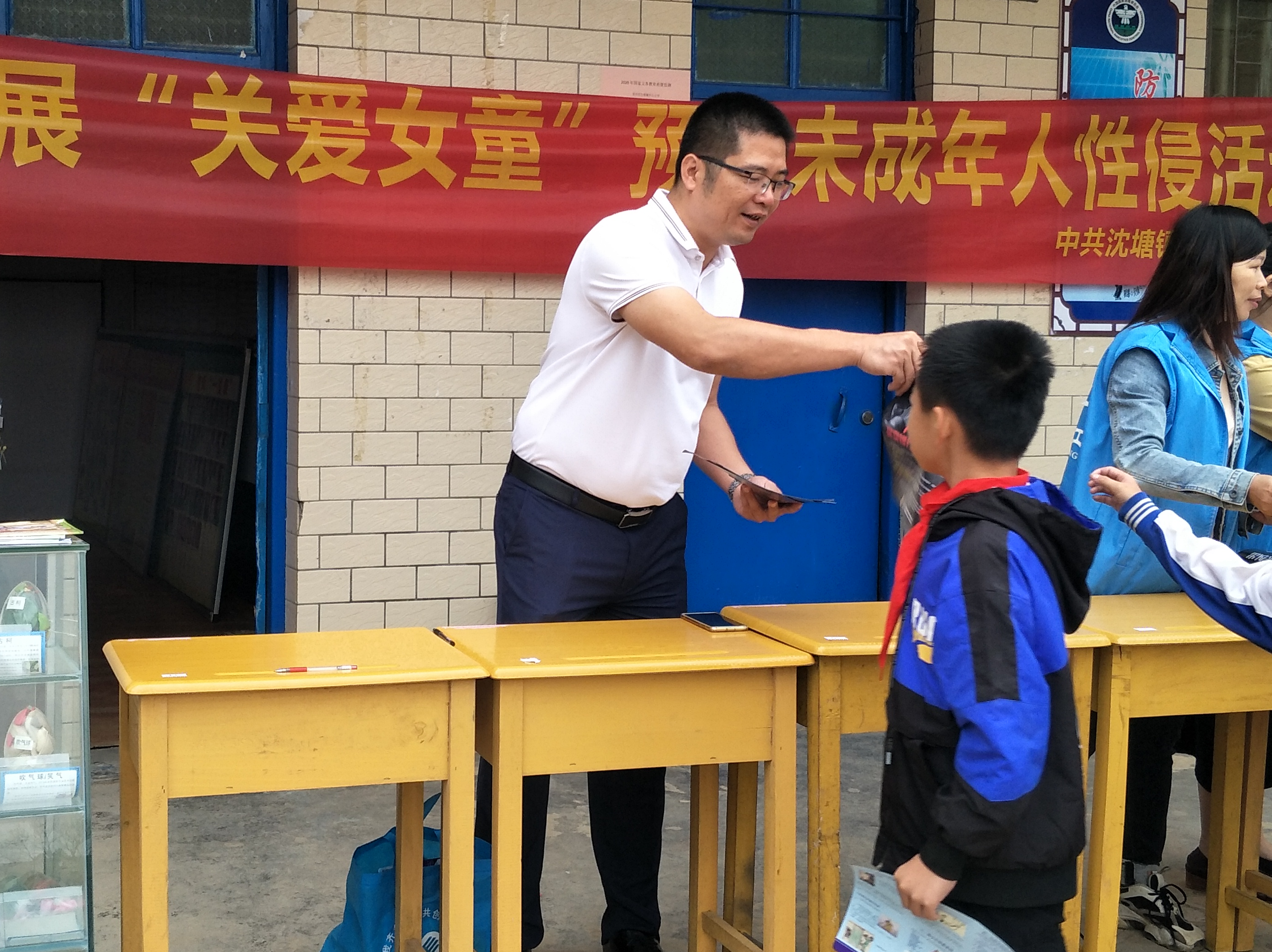 何景湘校长给同学们发放禁毒宣传资料.jpg